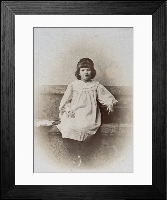 Framed Print : A girl, sitting on a stone bench with a fan folded at her side, c1890s. Creator: Arthur Reston Framed Print : A girl, sitting on a stone bench with a fan folded at her side, c1890s. Creator: Arthur Reston