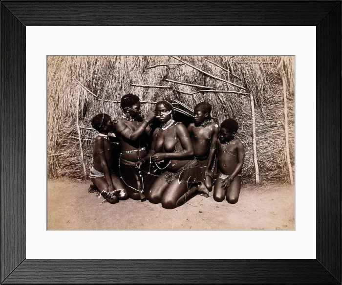 Framed Print : Africa: African women adorning themselves with beads, outside a kraal hut, 19th century. Creator: Unknown Framed Print : Africa: African women adorning themselves with beads, outside a kraal hut, 19th century. Creator: Unknown
