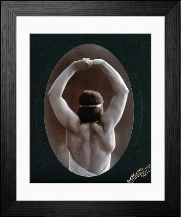 Framed Print : A young woman posing semi-naked, back view, with her arms in the air, in a photographic... c1903. Creator: Unknown Framed Print : A young woman posing semi-naked, back view, with her arms in the air, in a photographic... c1903. Creator: Unknown