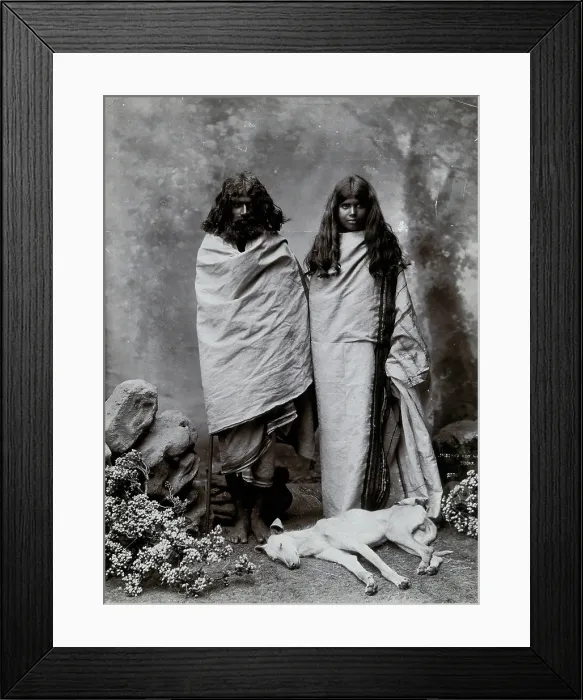 Framed Print : A man and woman of the Toda tribe standing in a photographic studio, with a dog lying... c1900. Creator: Unknown Framed Print : A man and woman of the Toda tribe standing in a photographic studio, with a dog lying... c1900. Creator: Unknown