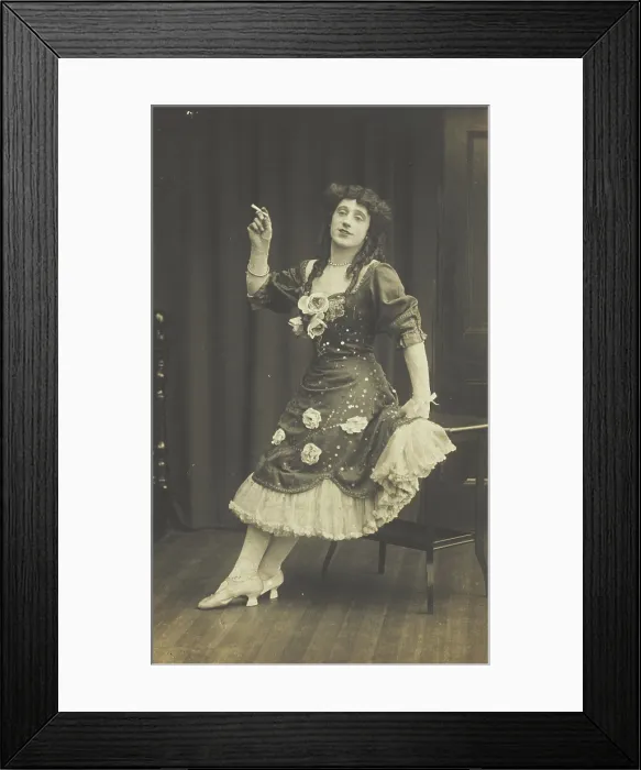 Framed Print : A performer in drag, wearing a large flowery dress, poses with a cigarette on stage, c1908-1910. Creator: Unknown Framed Print : A performer in drag, wearing a large flowery dress, poses with a cigarette on stage, c1908-1910. Creator: Unknown