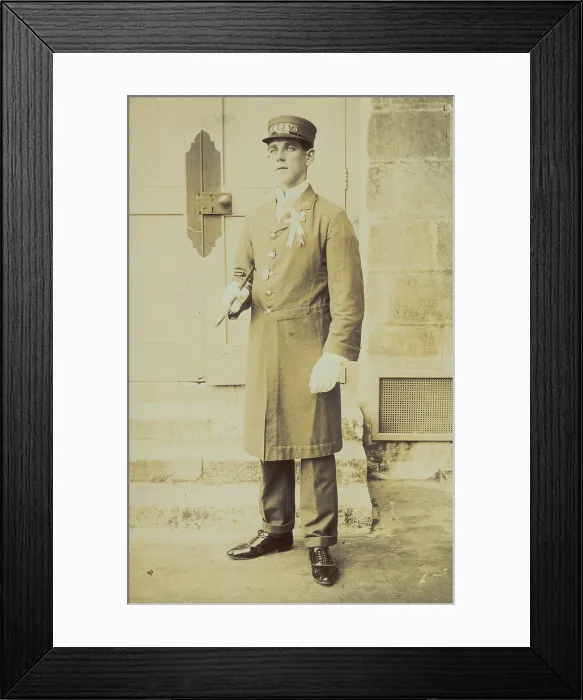 Framed Print : A man dressed wearing a long coat and a hat bearing the word 'Cook'...(1910-1919?). Creator: Unknown Framed Print : A man dressed wearing a long coat and a hat bearing the word 'Cook'...(1910-1919?). Creator: Unknown