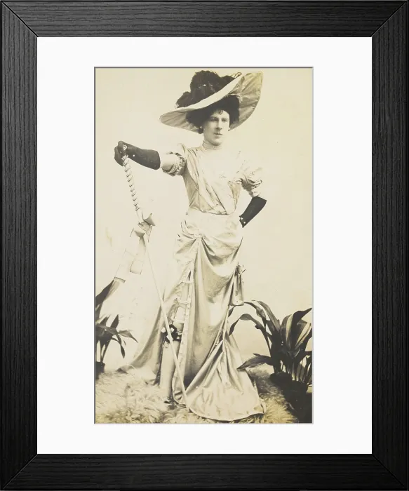 Framed Print : An man in drag is wearing a revealing dress and holding a staff, posing with his... 1909. Creator: Unknown Framed Print : An man in drag is wearing a revealing dress and holding a staff, posing with his... 1909. Creator: Unknown