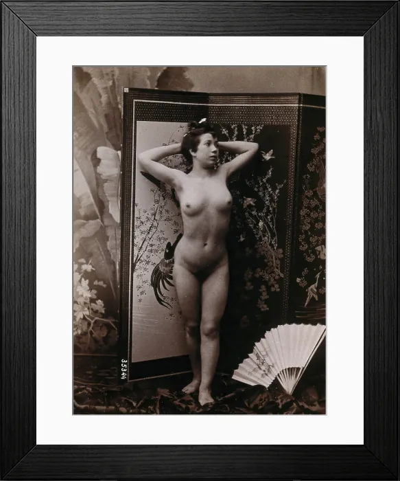 Framed Print : A young woman posing naked against a decorative dressing screen, c1900. Creator: Unknown Framed Print : A young woman posing naked against a decorative dressing screen, c1900. Creator: Unknown