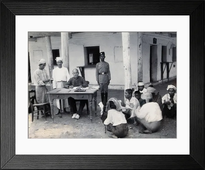 Framed Print : A man sitting at a table examining passports, during a plague epidemic in Mandalay, 1906. Creator: Unknown Framed Print : A man sitting at a table examining passports, during a plague epidemic in Mandalay, 1906. Creator: Unknown