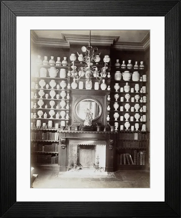 Framed Print : Drug jars and books on shelves surrounding a mantlepiece with a statue and a mirror, c1900.. Creator: Unknown Framed Print : Drug jars and books on shelves surrounding a mantlepiece with a statue and a mirror, c1900.. Creator: Unknown