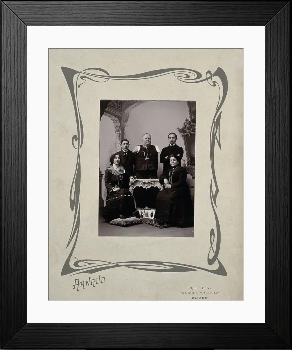 Framed Print : A family portrait: a man without arms and legs poses on a table surrounded by family, 20th Century. Creator: Unknown Framed Print : A family portrait: a man without arms and legs poses on a table surrounded by family, 20th Century. Creator: Unknown
