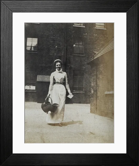 Framed Print : St Bartholomew's Hospital, London: a smiling nurse carrying a coal scuttle, c1890 Framed Print : St Bartholomew's Hospital, London: a smiling nurse carrying a coal scuttle, c1890