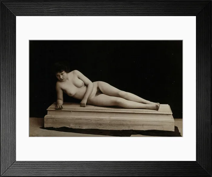 Framed Print : A young woman posing naked in a photographic studio, lying on a wooden plinth, approx 1900. Creator: Unknown Framed Print : A young woman posing naked in a photographic studio, lying on a wooden plinth, approx 1900. Creator: Unknown