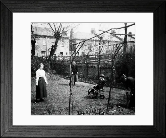 Framed Print : A physically disabled boy sitting in a wheelchair in the back garden of a semi... c1910 / 1925. Creator: Unknown Framed Print : A physically disabled boy sitting in a wheelchair in the back garden of a semi... c1910 / 1925. Creator: Unknown