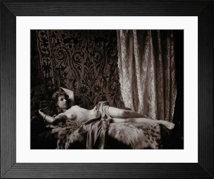 Framed Print : A young woman, posing semi-naked in a photographic studio, lying full-length on a fur... c1900. Creator: Unknown Framed Print : A young woman, posing semi-naked in a photographic studio, lying full-length on a fur... c1900. Creator: Unknown