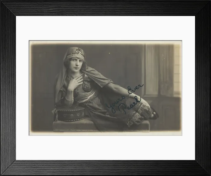 Framed Print : A man in drag, poses wearing delicate attire; curled up on a piece of furniture, [1910-1919?]. Creator: Unknown