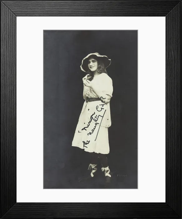Framed Print : An amateur actor in drag, posing as Ninon, wearing a white dress and hat, [between 1920 and 1929