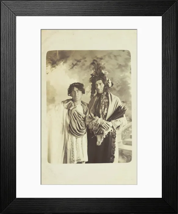 Framed Print : Two men in drag, one wearing a detailed feathered head garment, pose for a portrait, [1900-1909?]. Creator: Frank Wood