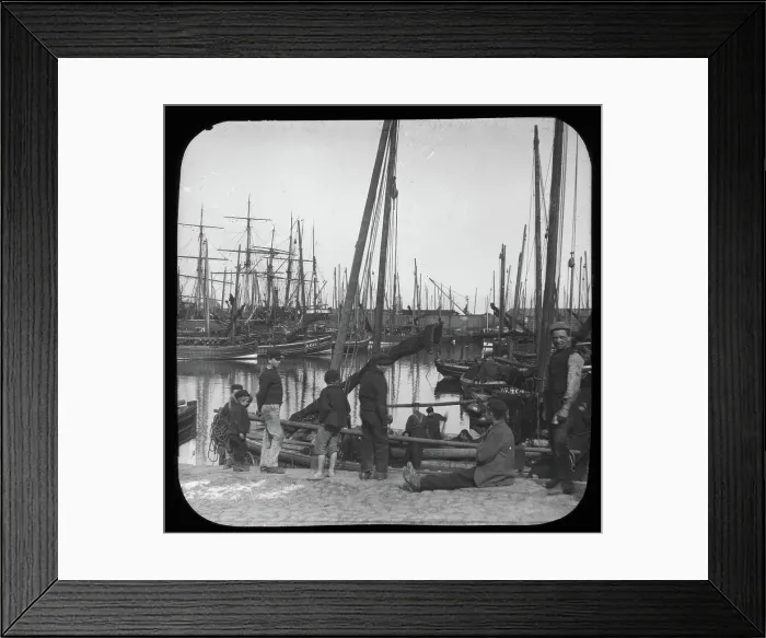 Framed Print : Men and boys with sailing boats in port, unknown location, c1900s Framed Print : Men and boys with sailing boats in port, unknown location, c1900s