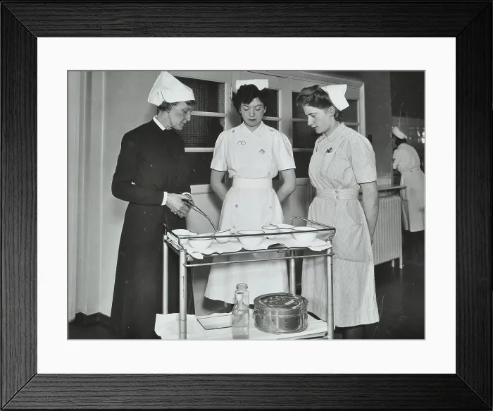 Framed Print : A Sister imparts knowledge and technical expertise to two trainee nurses, c1950s. Creator: Unknown Framed Print : A Sister imparts knowledge and technical expertise to two trainee nurses, c1950s. Creator: Unknown