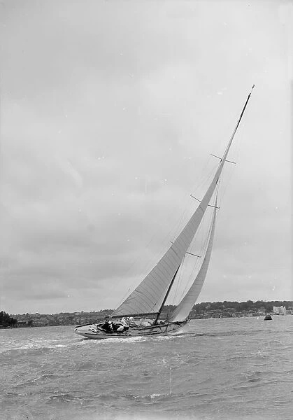 12 Metre class sailing yacht heeling over in windy conditions on upwind leg, 1938