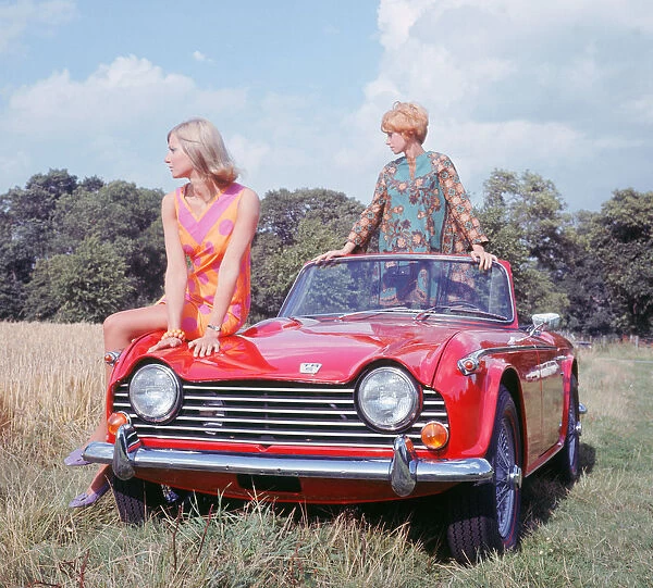 1968 Triumph TR5 with female models, (B. M. I. H. T. ). Creator: Unknown