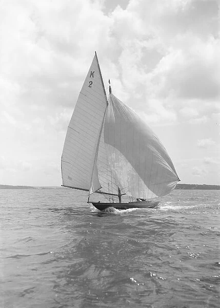 The 7 Metre yacht Ithnan (K2) sailing with spinnaker, 1912. Creator: Kirk & Sons of Cowes