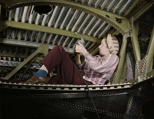 An A-20 bomber being riveted by a woman... Douglas Aircraft Company plant at Long Beach, Calif. 1942 Creator: Alfred T Palmer