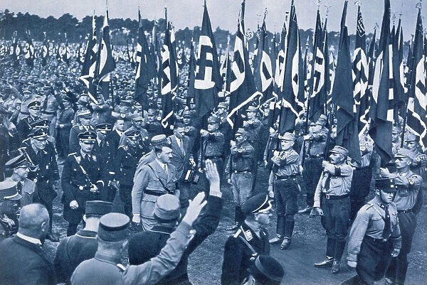 Adolf Hitler, escorted by SS leaders, inspects the SA at a Nazi rally in Nuremberg, 1933