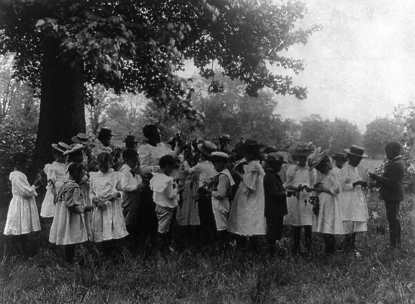 African American school children and teacher, studying leaves out of doors, (1899?). Creator: Frances Benjamin Johnston