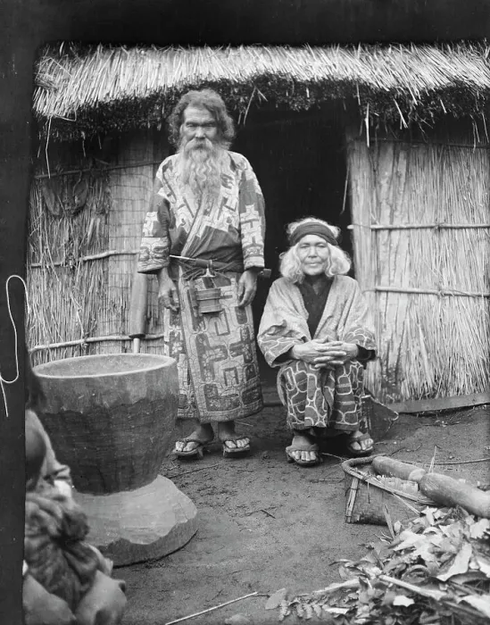 Framed Print : Ainu man and seated woman at the entrance of a hut, 1908. Creator: Arnold Genthe Framed Print : Ainu man and seated woman at the entrance of a hut, 1908. Creator: Arnold Genthe