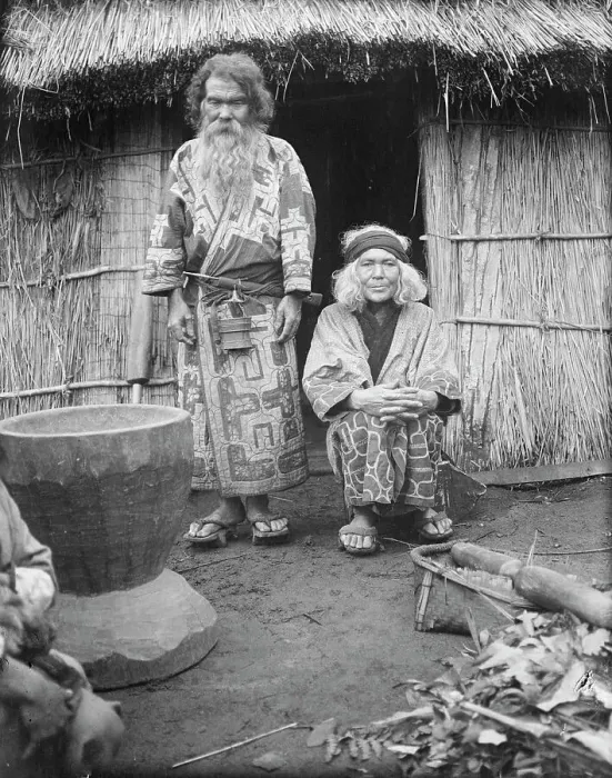 Framed Print : Ainu man and seated woman at the entrance of a hut, 1908. Creator: Arnold Genthe Framed Print : Ainu man and seated woman at the entrance of a hut, 1908. Creator: Arnold Genthe