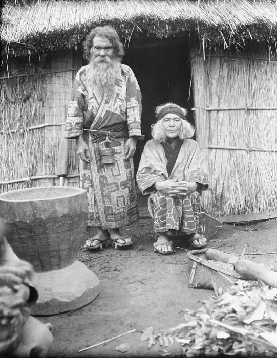 Framed Print : Ainu man and seated woman at the entrance of a hut, 1908. Creator: Arnold Genthe Framed Print : Ainu man and seated woman at the entrance of a hut, 1908. Creator: Arnold Genthe