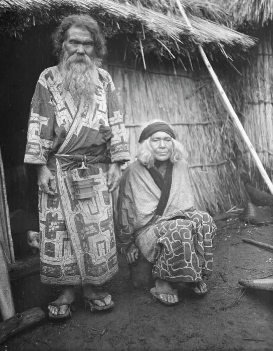 Framed Print : Ainu man and seated woman at the entrance of a hut, 1908. Creator: Arnold Genthe Framed Print : Ainu man and seated woman at the entrance of a hut, 1908. Creator: Arnold Genthe