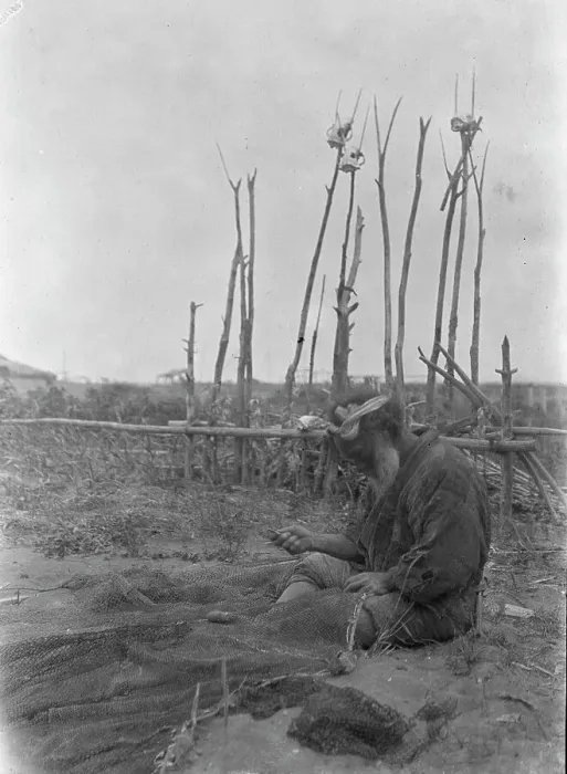 Framed Print : Ainu seated outside working on nets, 1908. Creator: Arnold Genthe Framed Print : Ainu seated outside working on nets, 1908. Creator: Arnold Genthe
