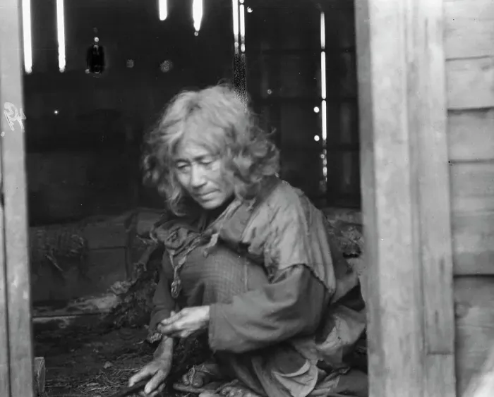Framed Print : Ainu woman seated in the doorway of a wooden hut, 1908. Creator: Arnold Genthe Framed Print : Ainu woman seated in the doorway of a wooden hut, 1908. Creator: Arnold Genthe