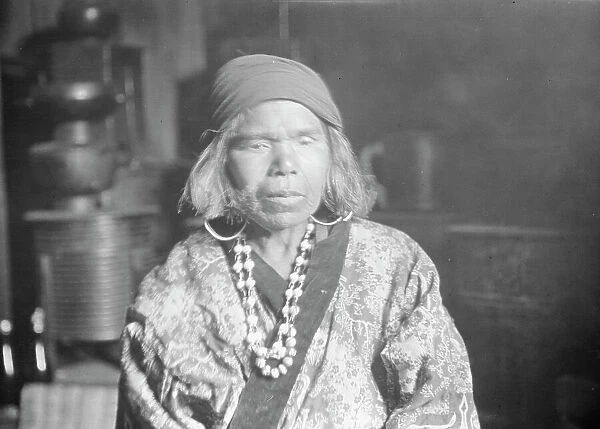 Ainu woman wearing a headscarf, earrings, and a necklace, 1908. Creator: Arnold Genthe