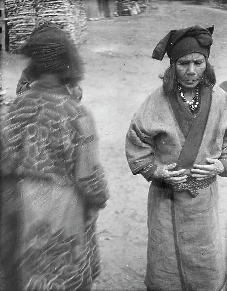 Two Ainu women in the village lane, 1908. Creator: Arnold Genthe