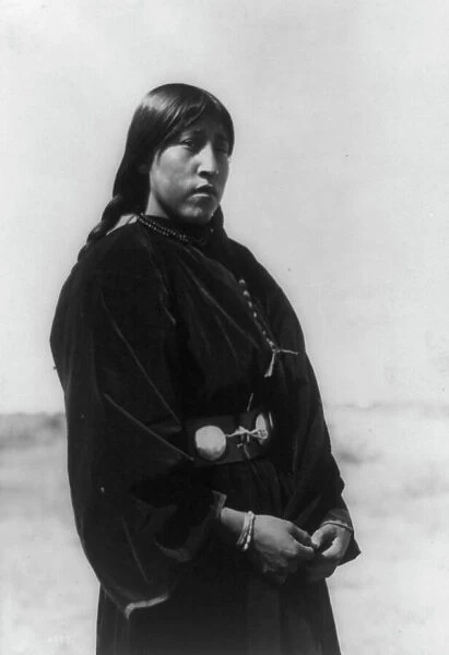 Arapaho maiden, three-quarter-length portrait, standing, facing right, c1910. Creator: Edward Sheriff Curtis