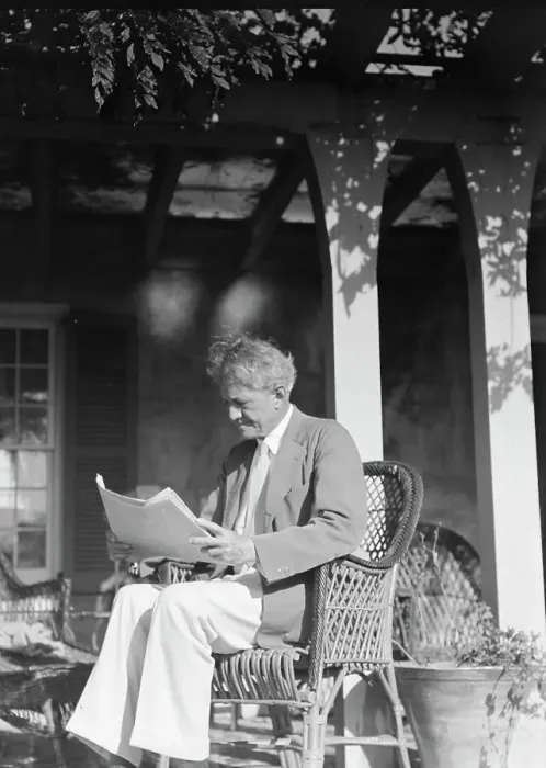 Framed Print : Arnold Genthe seated outdoors in a wicker chair reading, between 1911 and 1942. Creator: Arnold Genthe Framed Print : Arnold Genthe seated outdoors in a wicker chair reading, between 1911 and 1942. Creator: Arnold Genthe