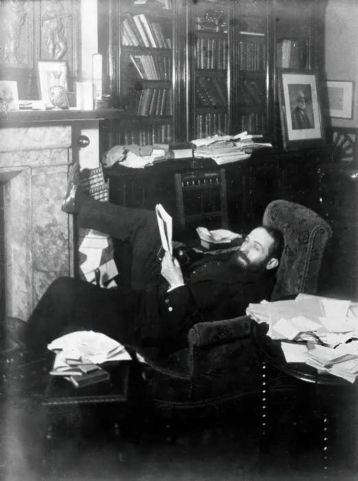 Framed Print : Arthur Schuster, lying on an armchair by a fireplace, with a photograph of Lord Kelvin... c1901. Creator: Unknown Framed Print : Arthur Schuster, lying on an armchair by a fireplace, with a photograph of Lord Kelvin... c1901. Creator: Unknown