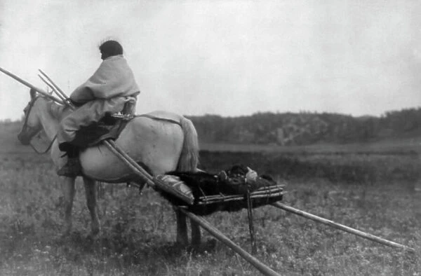 Atsina Indian on horse pulling travois, c1908. Creator: Edward Sheriff Curtis