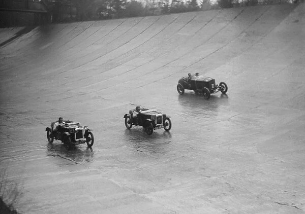 Two Austin 7s and an unidentified car racing at a BARC meeting, Brooklands, Surrey