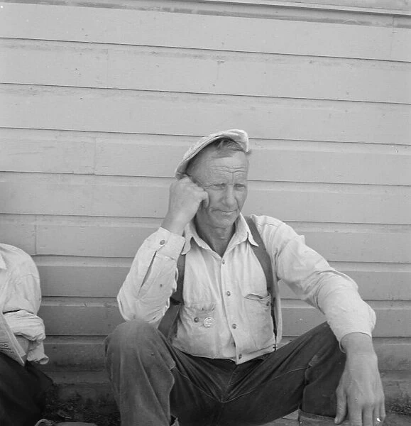 Bindle stiff, used to be logger, Side of Pastime Cafe, Tulelake, Siskiyou County, California, 1939. Creator: Dorothea Lange
