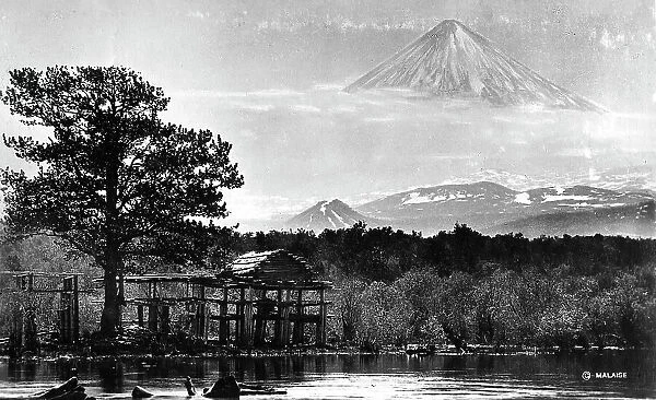 Booths on the river bank against the backdrop of Klyuchevsky volcano, 1922-1923. Creator: Rene Malaise