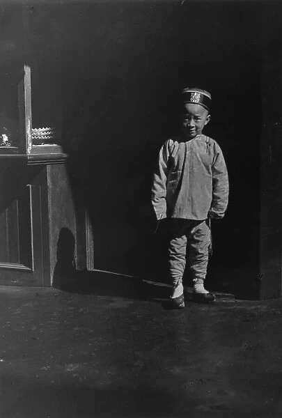 Boy in doorway of lamp store, Chinatown, San Francisco, between 1896 and 1906. Creator: Arnold Genthe
