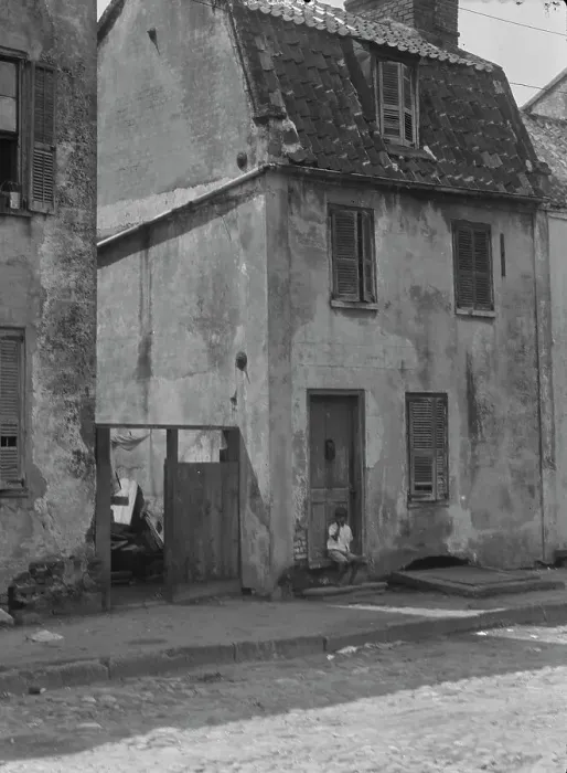 Framed Print : Boy sitting in the doorway of a two-story building, [17 Chalmers Street], Charleston... c1920-c1926 Creator: Arnold Genthe