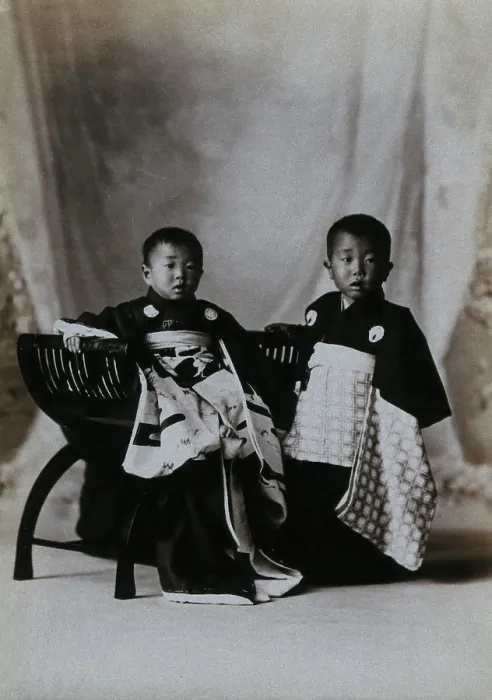 Framed Print : Two boys in a photographic studio, one seated on a chair, in front of a curtained backdrop, c1900. Creator: Unknown Framed Print : Two boys in a photographic studio, one seated on a chair, in front of a curtained backdrop, c1900. Creator: Unknown