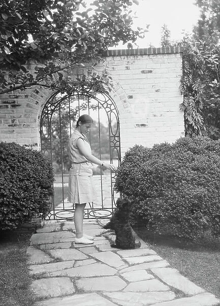 Brady, Genevieve, Miss, with dog, standing outdoors, between 1928 and 1931. Creator: Arnold Genthe