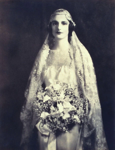 Bride holding a wedding bouquet, facing front, three-quarter length portrait, between 1920 and 1930. Creator: Unknown