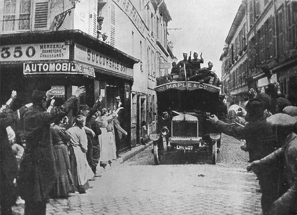 British troops receive a welcome as they arrive by motor van in a French town, 1915