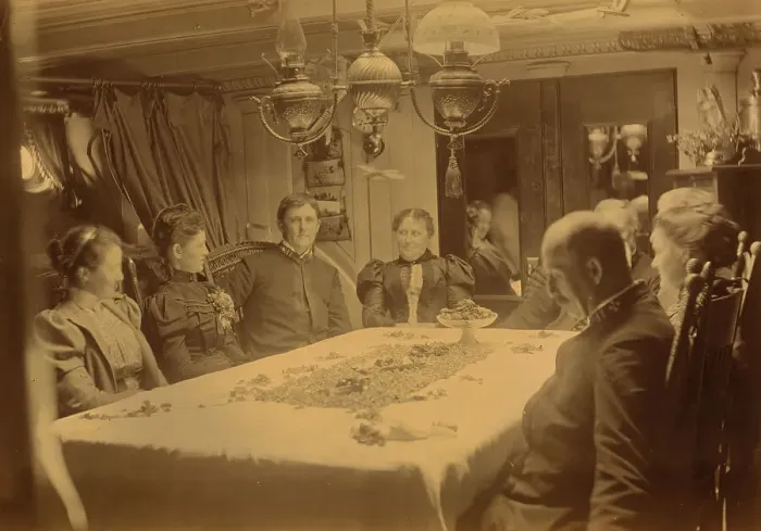 Framed Print : Captains, their wives, and two female tourists sitting around a table aboard ship...Alaska, (1897?) Creator: Alfred Lee Broadbent Framed Print : Captains, their wives, and two female tourists sitting around a table aboard ship...Alaska, (1897?) Creator: Alfred Lee Broadbent