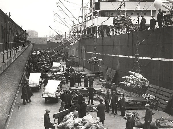 Cargo being loaded or unloaded from a ship, Royal Victoria Dock, Canning Town, London, c1930