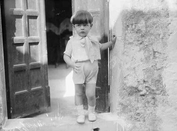 Cenerini, Mr. child of, standing in a doorway, 1929 Creator: Arnold Genthe